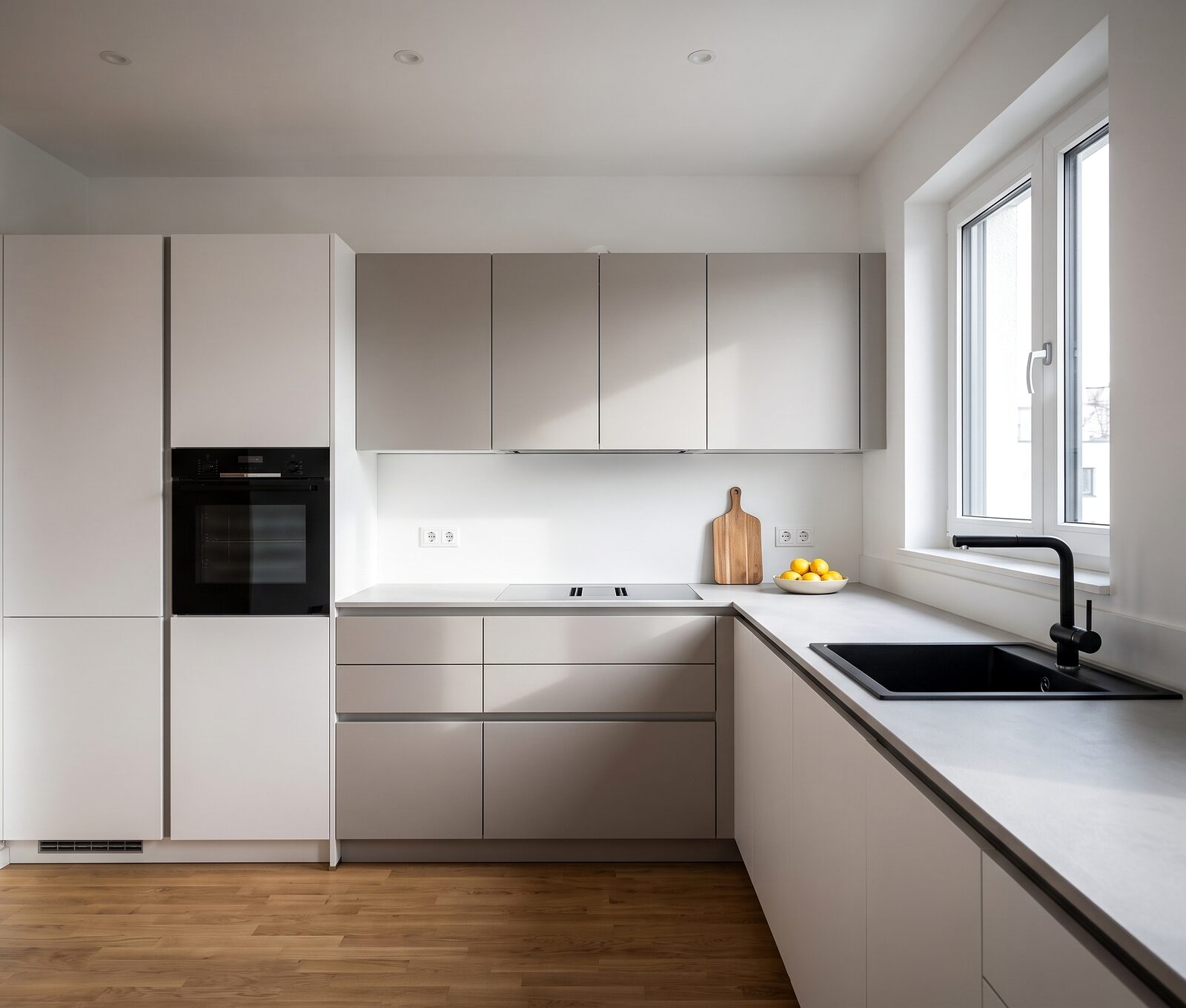 Stilwelt Modern: grifflose Fronten in Weiß und Greige, helle Keramik-Arbeitsplatte, schwarze Spüle